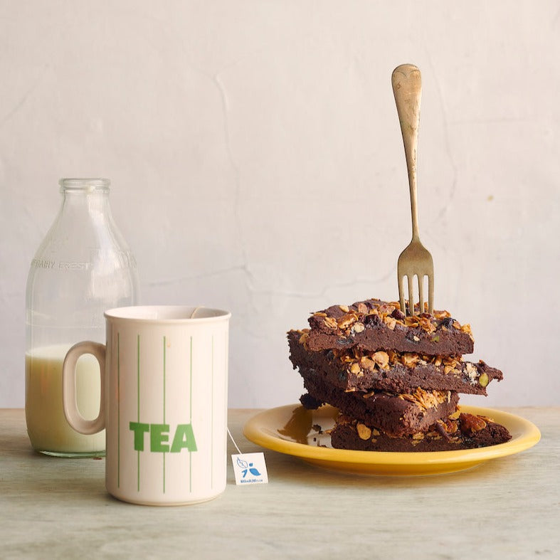Fruit and Nut Brownie stacked next to a bottle of milk and Bird Blend Tea