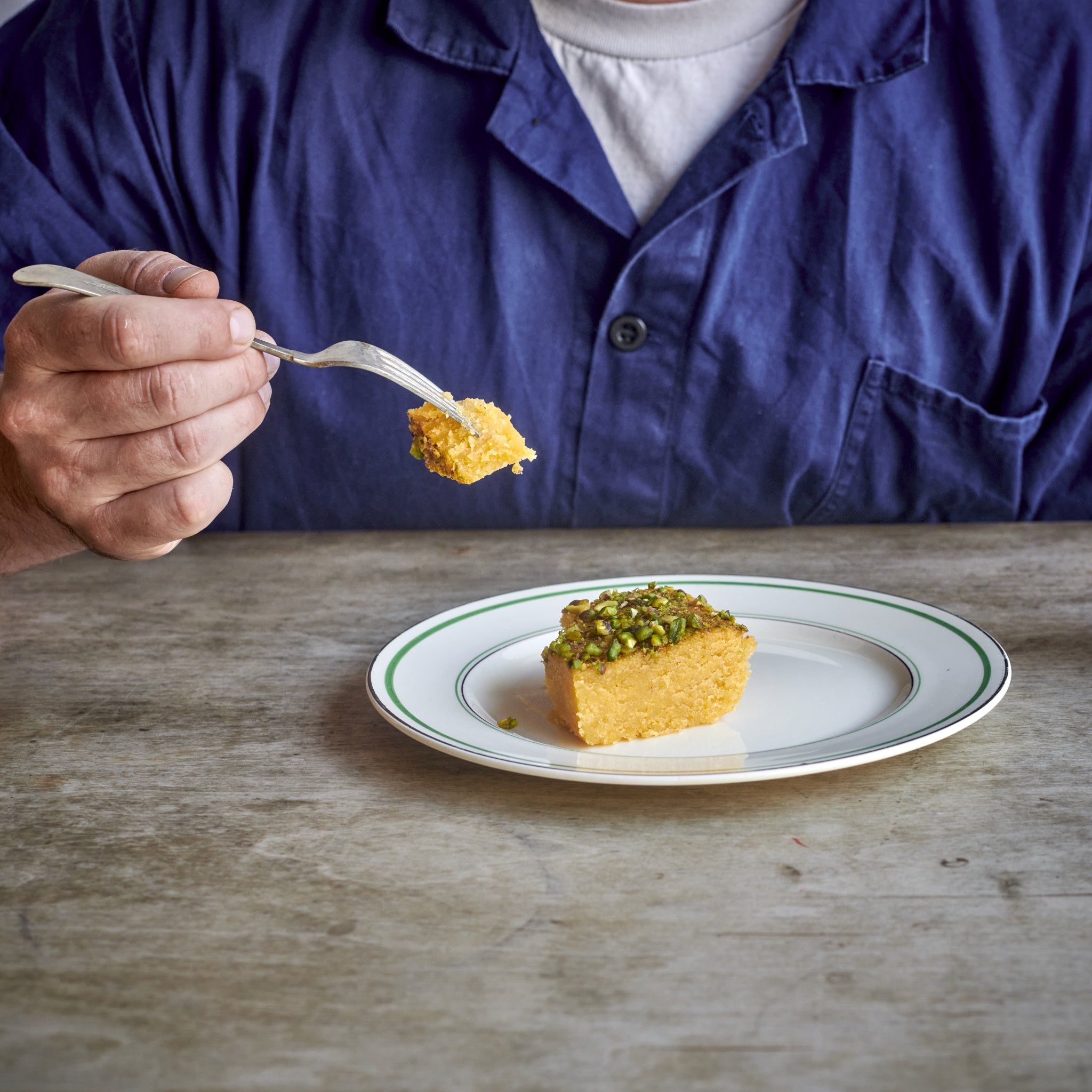 A portion of Exploding Bakery Lemon Polenta & Pistachio Cake being eaten.