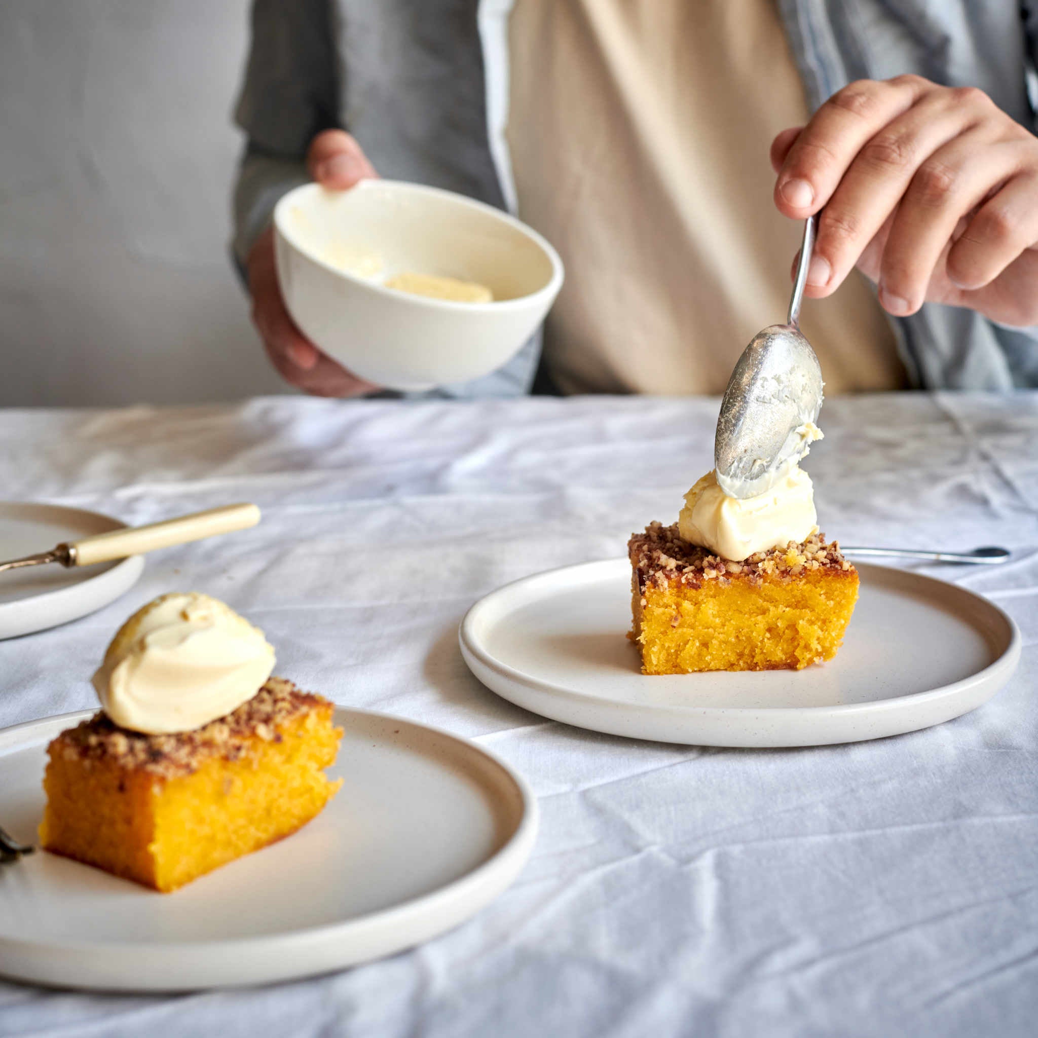 The Exploding Bakery Orange Almond & Pecan Cake portion served with cream.