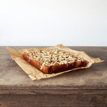 Miso Blondie with white chocolate drizzle on baking paper on a table