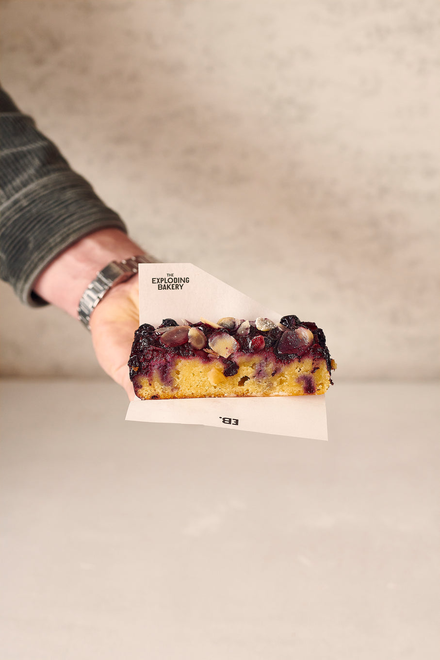 Someone holding a slice of the Blackcurrant Frangipane