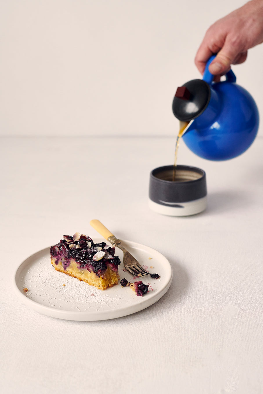 Plated slice of Blackcurrant Frangipane and a cup of Suki Tea