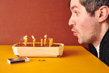 Candles being blown out on an Exploding Bakery Cake