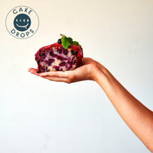 a slice of Blackcurrant Friand Loaf in the plam of a hand.