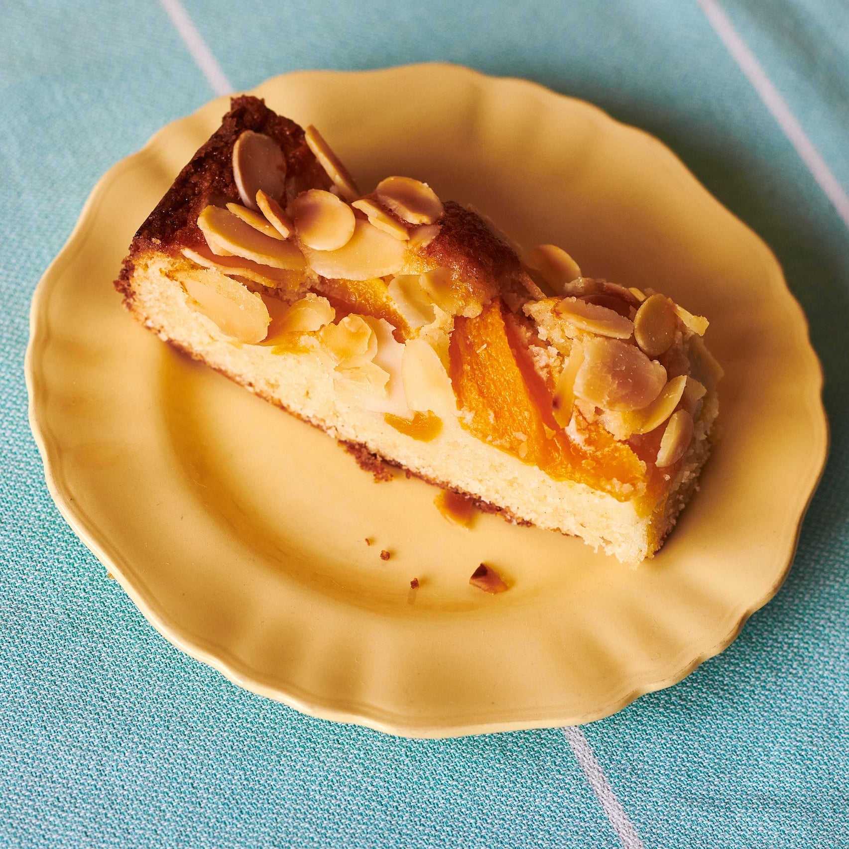 A slice of Peach, Ricotta & Almond Cake
on a plate photographed from above.