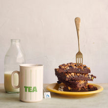 A stack of Fruit and Nut brownie next to a bottle of milk and Bird Blend Breakfast Tea