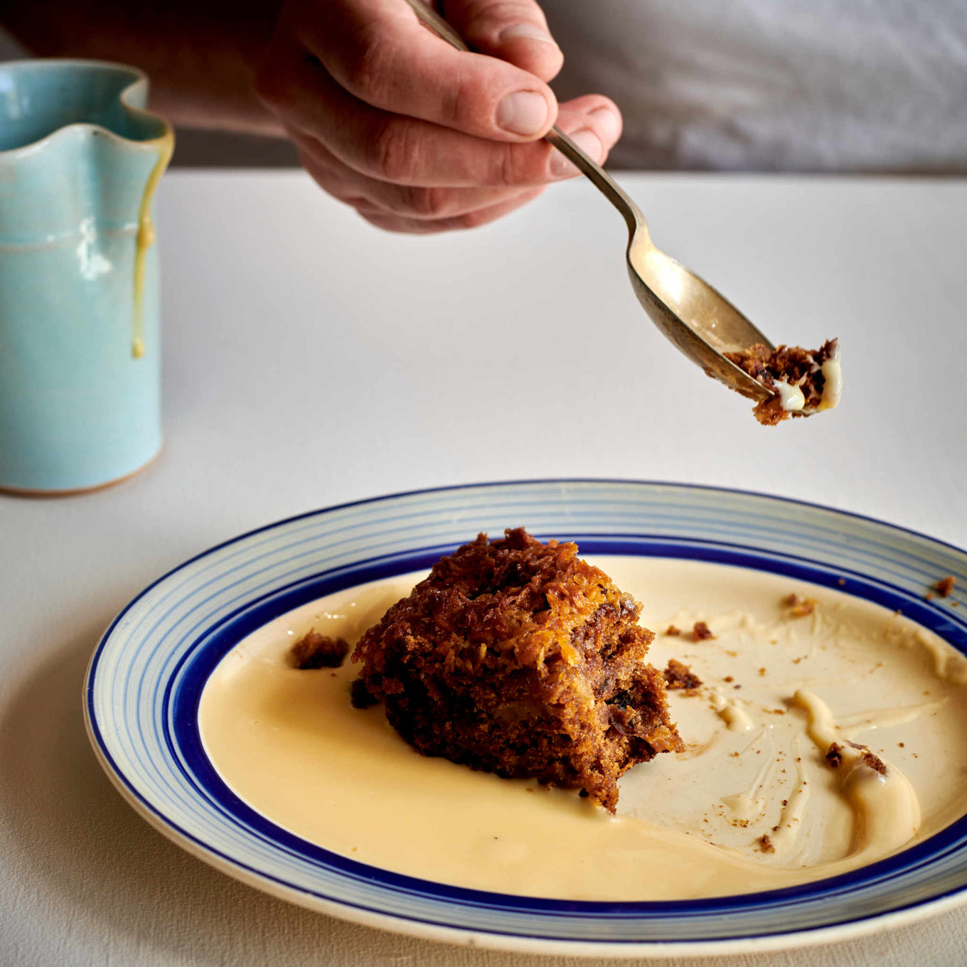 Exploding Bakery Lumberjack Cake portion being eating with custard.