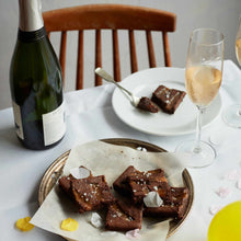 Exploding Bakery Salted Caramel Letterbox brownie cut up into portions and served with sparkling wine.